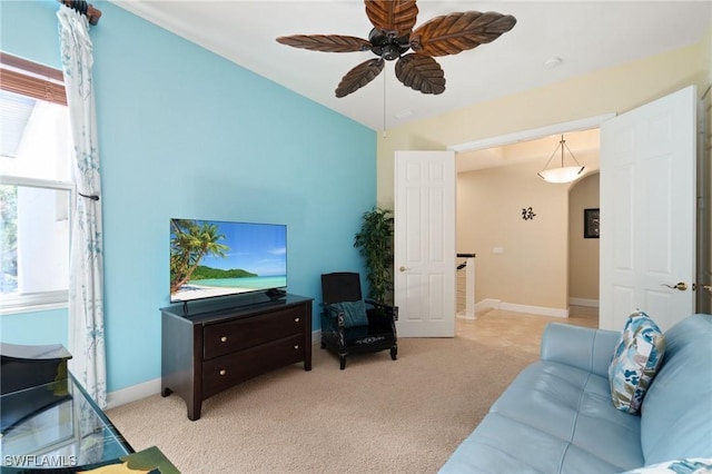 living room featuring a ceiling fan, light colored carpet, and baseboards