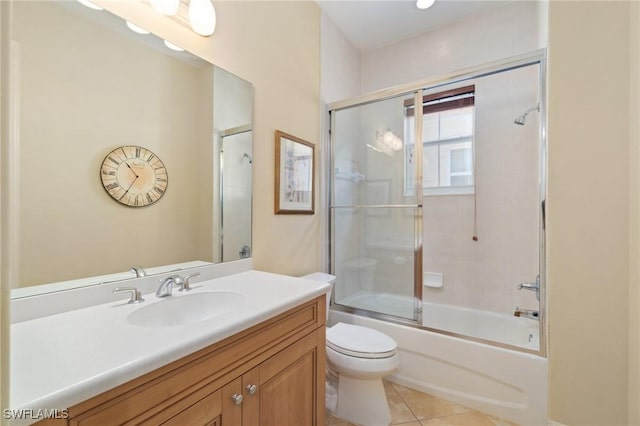 bathroom featuring enclosed tub / shower combo, vanity, toilet, and tile patterned floors