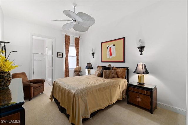 bedroom featuring light carpet, baseboards, a ceiling fan, and ensuite bathroom