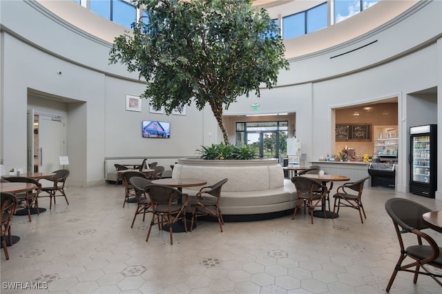 dining space featuring a towering ceiling and wine cooler