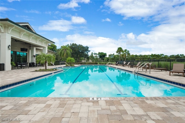 community pool featuring a ceiling fan, fence, and a patio