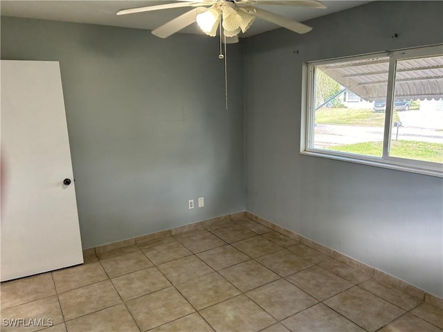 spare room with a ceiling fan and light tile patterned flooring