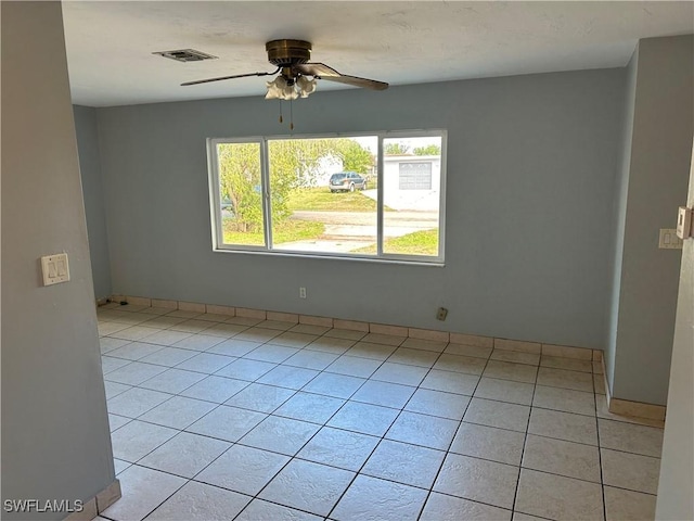 spare room featuring ceiling fan, visible vents, and light tile patterned flooring