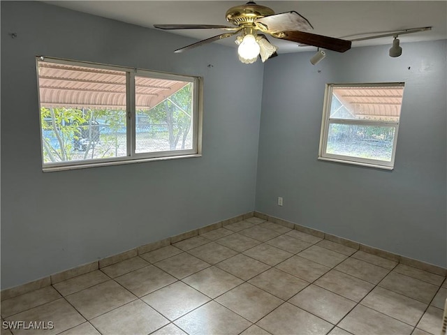 unfurnished room featuring light tile patterned floors, ceiling fan, baseboards, and rail lighting