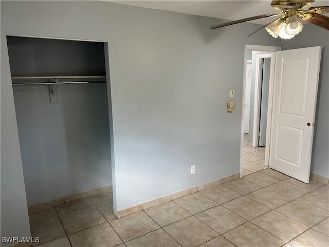 unfurnished bedroom featuring ceiling fan, baseboards, a closet, and light tile patterned flooring