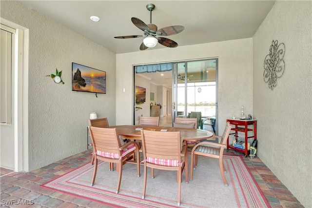 dining room with a textured wall and a ceiling fan