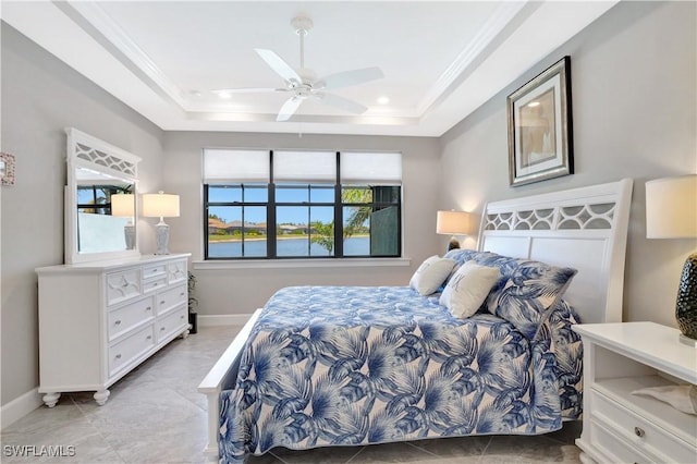 bedroom featuring baseboards, a raised ceiling, and crown molding