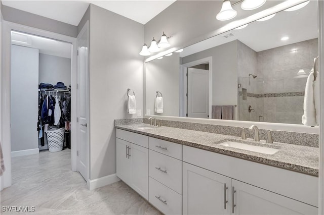 bathroom with a sink, a spacious closet, a shower stall, and double vanity