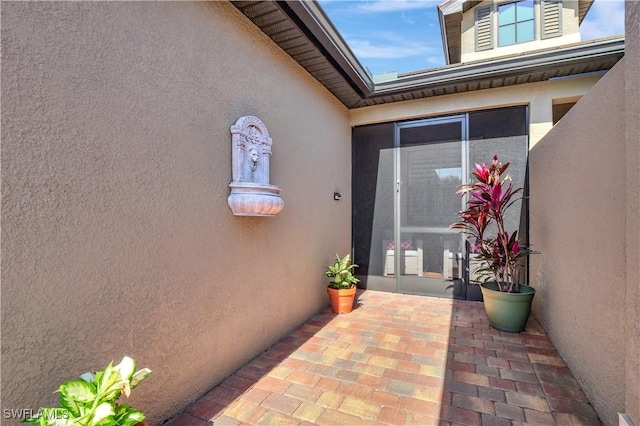 property entrance featuring a patio and stucco siding