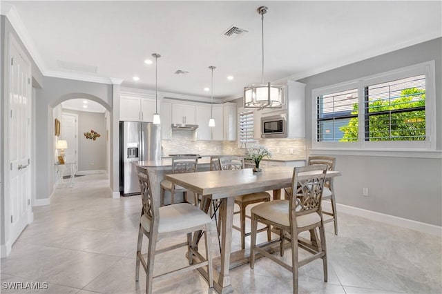 dining room with arched walkways, recessed lighting, visible vents, ornamental molding, and baseboards