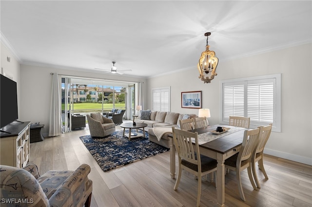 dining room with baseboards, ceiling fan with notable chandelier, light wood-type flooring, and crown molding