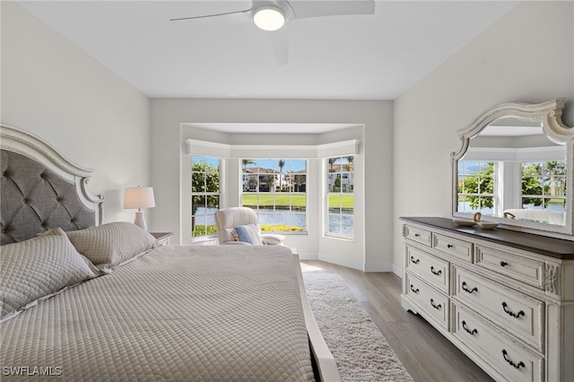 bedroom featuring ceiling fan, baseboards, and wood finished floors