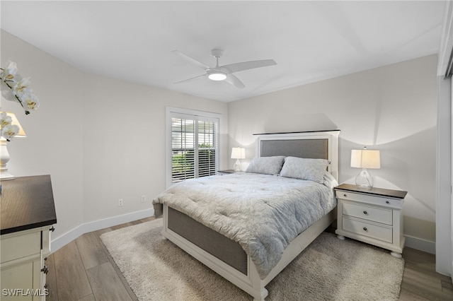 bedroom featuring ceiling fan, light wood finished floors, and baseboards