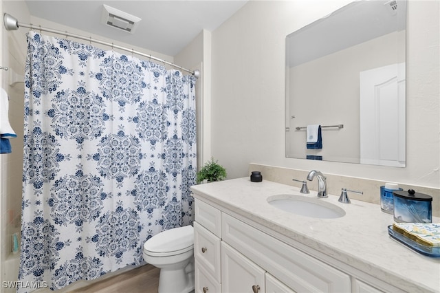 bathroom with visible vents, vanity, and toilet