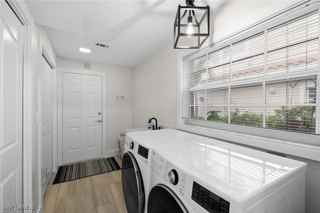 laundry area featuring laundry area, visible vents, washer and clothes dryer, and light wood finished floors