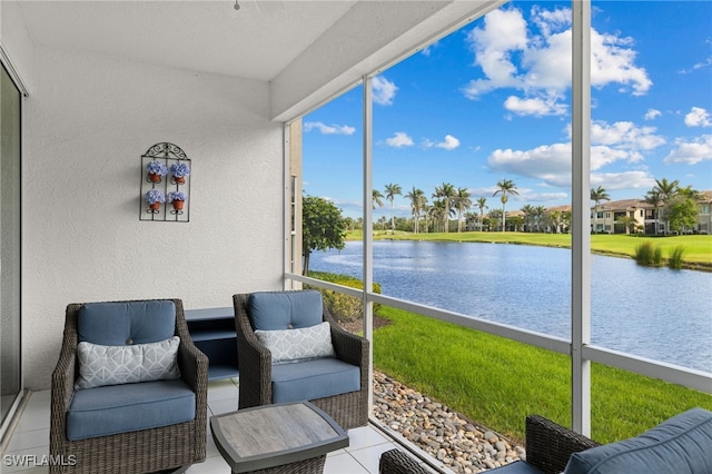 sunroom featuring a water view