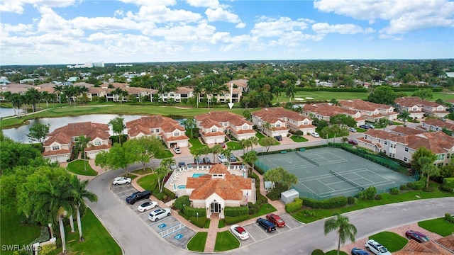 drone / aerial view featuring a residential view, view of golf course, and a water view