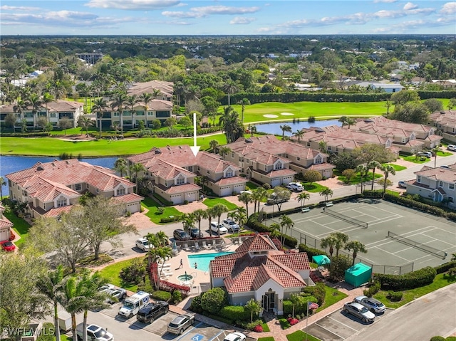 drone / aerial view with a water view, view of golf course, and a residential view