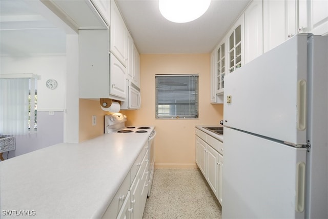 kitchen featuring white appliances, white cabinetry, glass insert cabinets, and light countertops