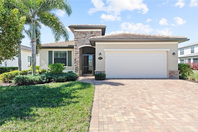 view of front facade featuring stone siding, stucco siding, an attached garage, decorative driveway, and a front yard