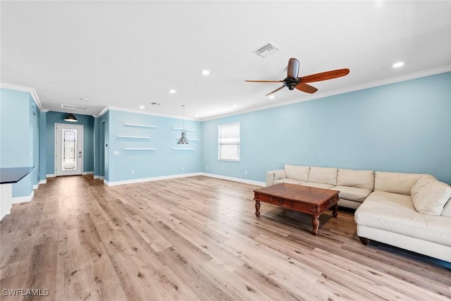 unfurnished living room with ornamental molding, visible vents, light wood-style flooring, and baseboards