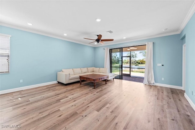 unfurnished living room with ornamental molding, light wood-style floors, visible vents, and baseboards