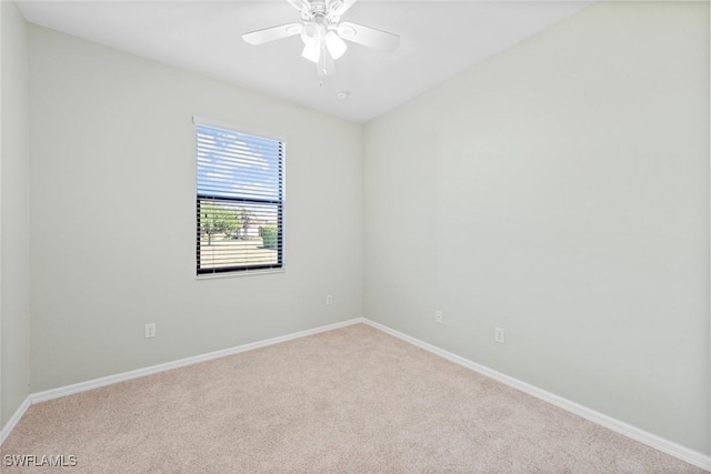 spare room with carpet floors, a ceiling fan, and baseboards