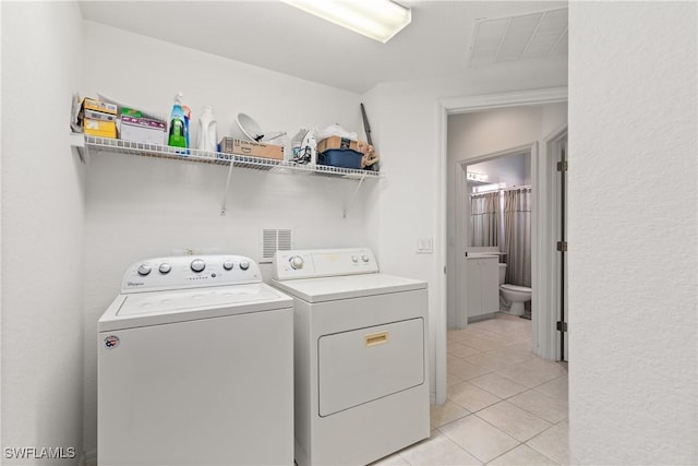 laundry area with washer and dryer, laundry area, visible vents, and light tile patterned floors