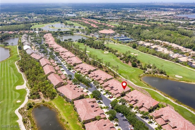 drone / aerial view featuring view of golf course, a water view, and a residential view