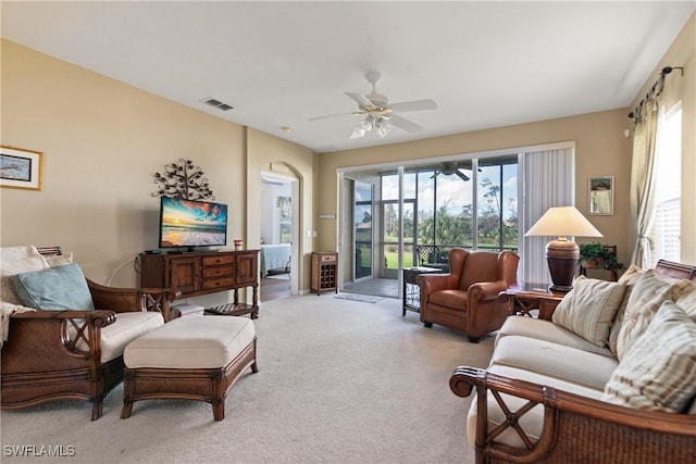 living room with light carpet, a ceiling fan, visible vents, and a wealth of natural light