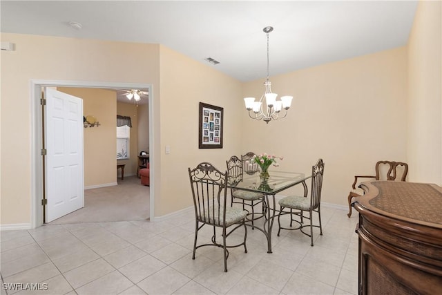 dining room featuring ceiling fan with notable chandelier, light tile patterned flooring, visible vents, and baseboards