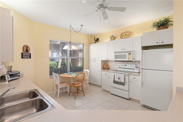 kitchen featuring light countertops, white appliances, and white cabinets