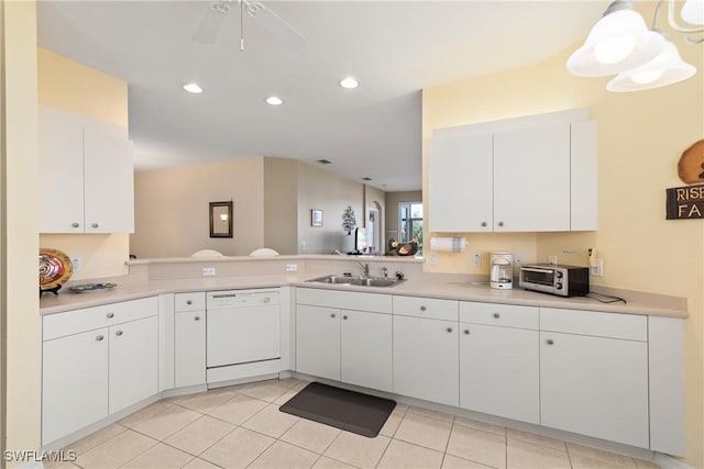 kitchen with light countertops, white cabinetry, dishwasher, and a sink