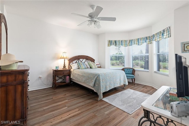 bedroom with ceiling fan, baseboards, and wood finished floors