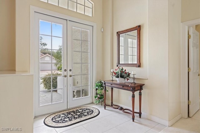 tiled foyer featuring baseboards and french doors