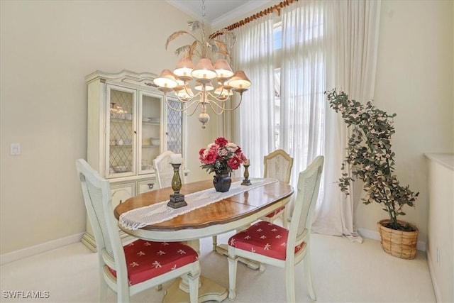 dining space with carpet, baseboards, a chandelier, and crown molding