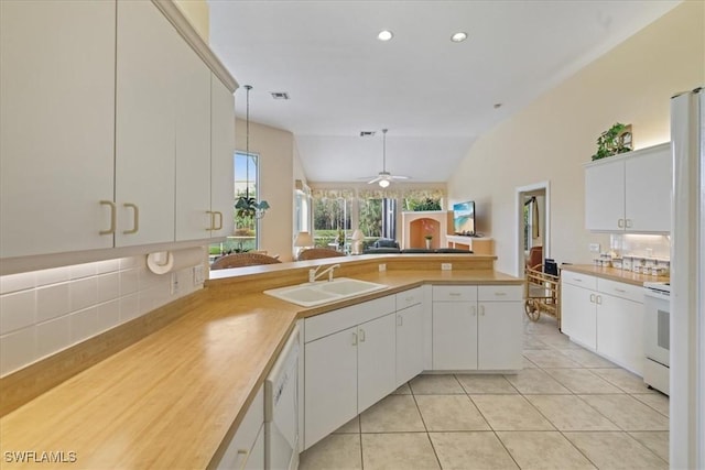 kitchen featuring light tile patterned floors, a peninsula, range with electric stovetop, a sink, and light countertops