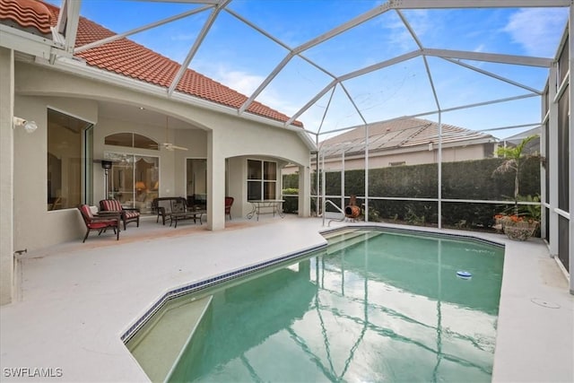 view of pool with a patio area, ceiling fan, glass enclosure, and a fenced in pool