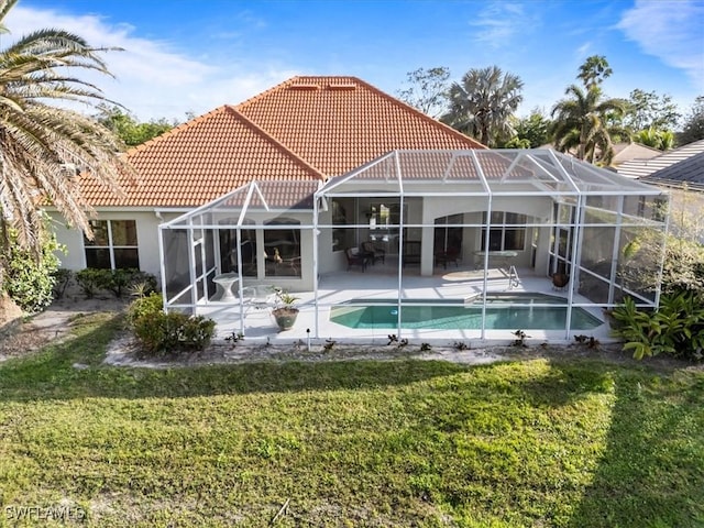 back of property with a yard, a lanai, a patio, and a tiled roof