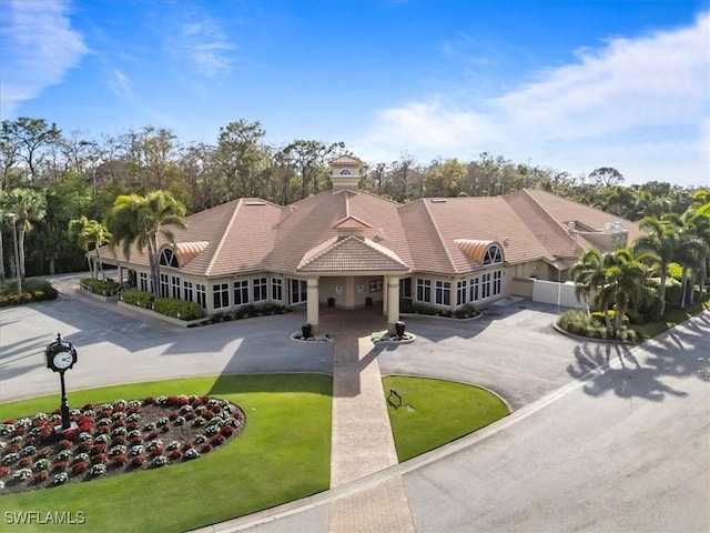 view of front of home with a front yard, aphalt driveway, and a tiled roof