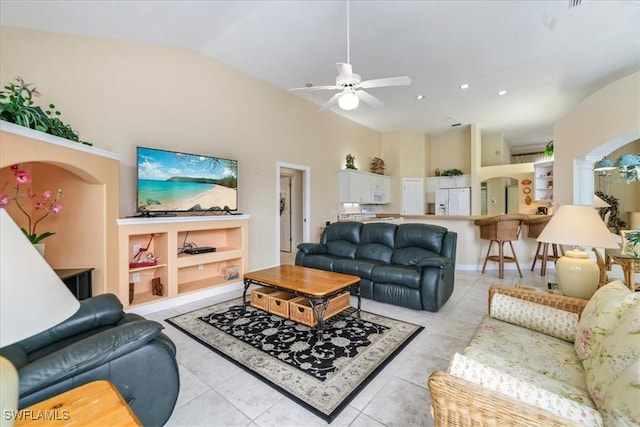 living area with ceiling fan, arched walkways, light tile patterned flooring, and lofted ceiling