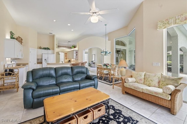 living area featuring light tile patterned floors, ceiling fan, arched walkways, and recessed lighting