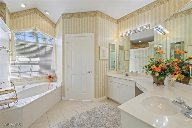 bathroom featuring tile patterned flooring, a garden tub, a sink, and wallpapered walls