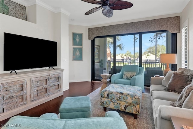 living room featuring ornamental molding, a ceiling fan, baseboards, and wood finished floors