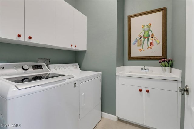 laundry area with light tile patterned flooring, washing machine and dryer, a sink, baseboards, and cabinet space