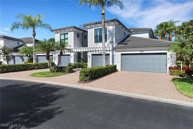 view of front of home featuring a garage, decorative driveway, and stucco siding