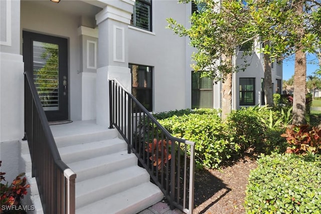 doorway to property featuring stucco siding