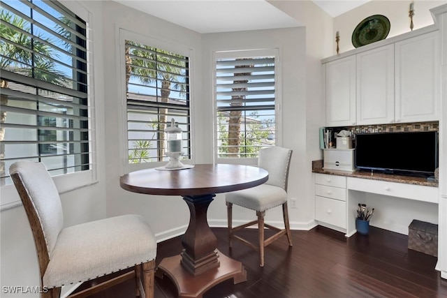 dining space with dark wood-style floors, built in desk, and baseboards