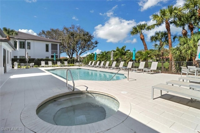 pool with a community hot tub, a patio area, and fence