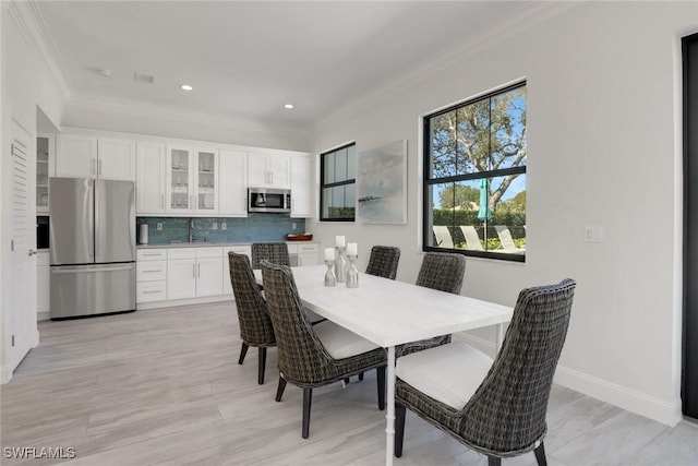 dining room with ornamental molding, recessed lighting, and baseboards